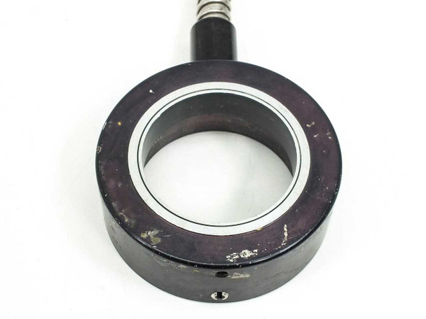 Close-up of ring housing front face on second unit showing heavier surface scuffing and paint wear on black anodized housing, small set screw visible at bottom