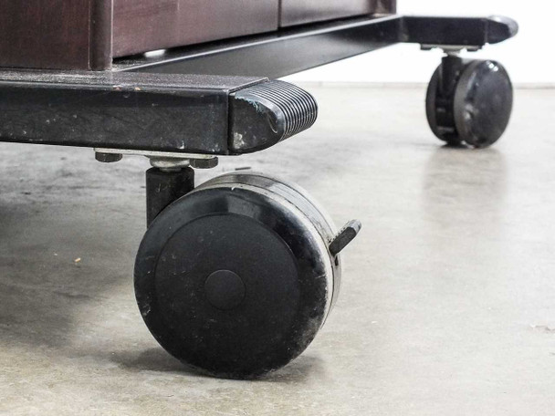 Close-up of heavy-duty swivel casters at base of cart showing rubber wheels and metal yoke