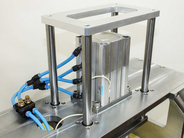 Pneumatic actuator assembly of ZIF rivet tool showing KCC air cylinder on aluminum gantry with blue pneumatic fittings and tubing