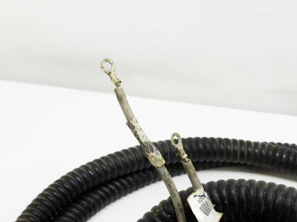 Cable harness end detail showing two bare wires with ring-terminal crimp connectors and visible wear on insulation