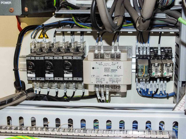 Controller enclosure electrical panel — circuit breakers (Fuji 7.5A), Omron S82K-05024 power supply, contactors