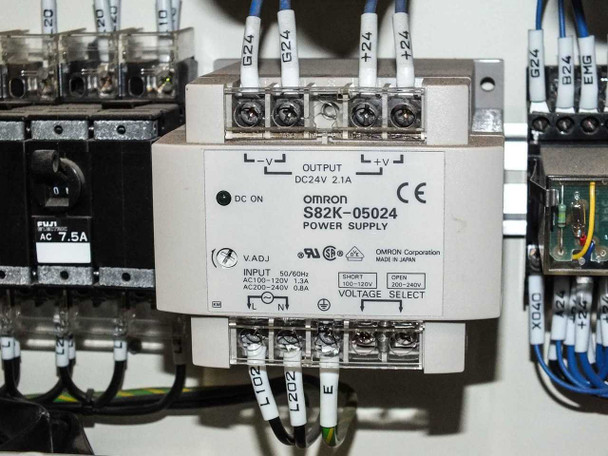 Omron S82K-05024 power supply close-up — DC24V 2.1A output, AC100-240V input, voltage selector visible