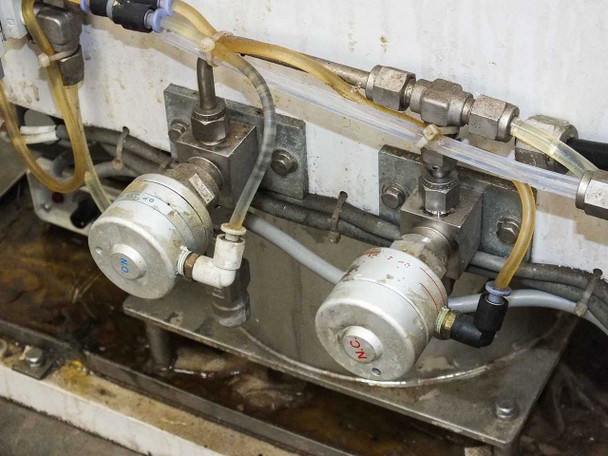 Dual diaphragm valve manifold detail – two valves with tubing connections mounted on stainless bracket inside frame