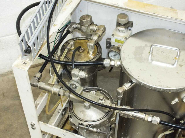Top-down view of lacquer dispensing system showing stainless vessel lids, compression fittings, hose connections, and pressure gauge