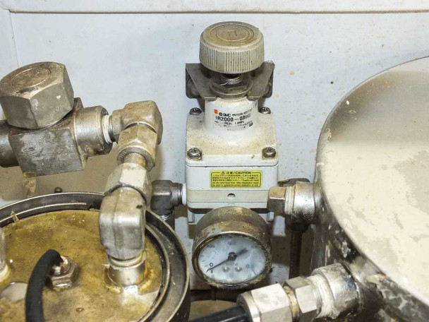 Close-up of SMC AR3000 pressure regulator and inline pressure gauge with stainless fittings and manifold plumbing