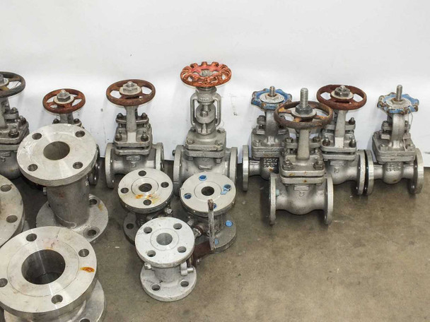 Row of stainless steel flanged gate valves with red and blue handwheels alongside stainless flange fittings