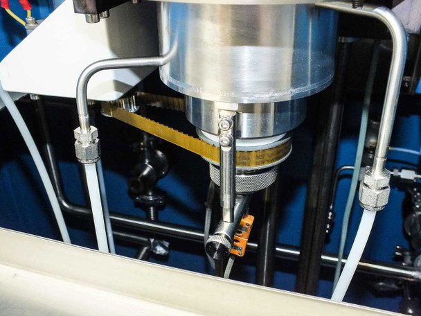 Underside of quartz reactor assembly showing reactor base, gas line connections, susceptor mount, and orange sensor
