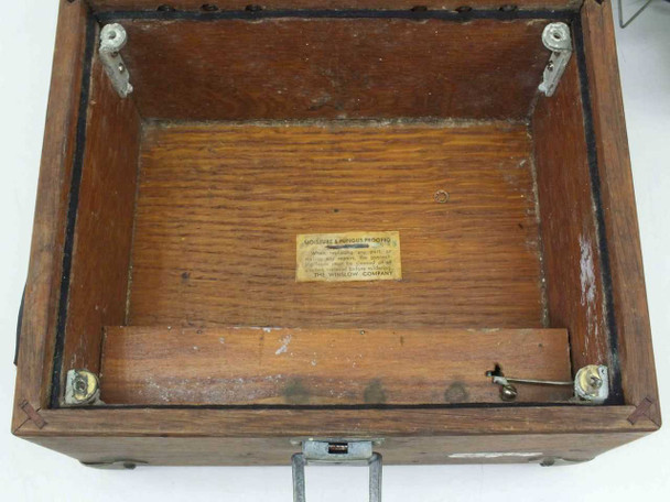 Interior of Winslow Co Type 301 oak case — empty lower compartment showing original patent/manufacturer label on base and battery compartment latch