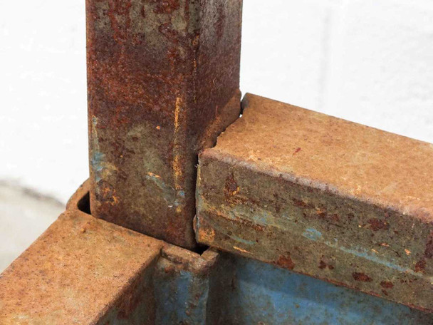 Close-up of broken weld at lower vertical section joint on Cost Cutter cart upright frame — visible crack and separation at weld point