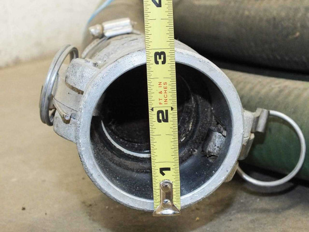 Interior bore of 2-inch aluminum cam lock coupling measured with tape measure showing approximately 2-inch diameter