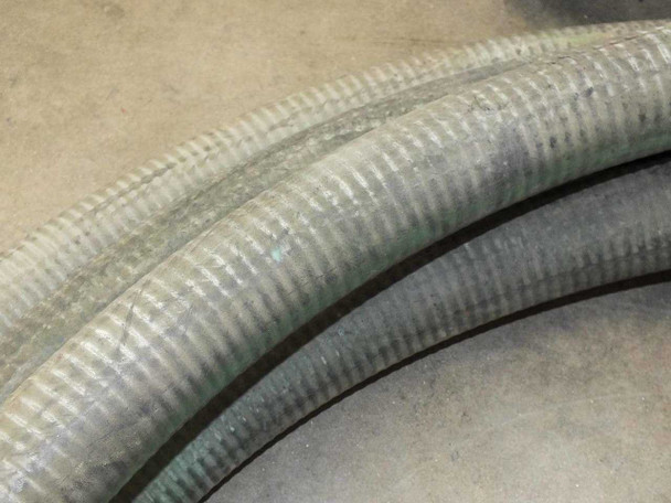 Close-up of corrugated flexible hose body showing surface wear and weathering along the length