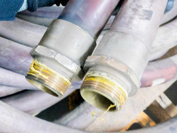Close-up of both Dixon male threaded end fittings with yellow thread sealant tape visible