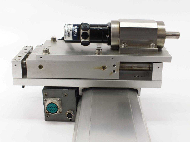 Close-up of Yamaha linear slide carriage end showing Sanyo Denki L404 motor, gearhead, shaft output, and 19-pin circular connector with M12 connector below