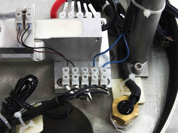 Close-up of base platform wiring area showing terminal block, Kendrion solenoid connections, coiled cables, and brass fitting