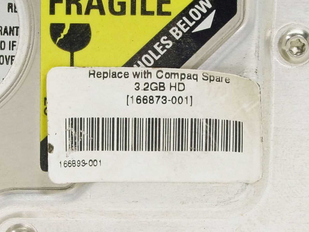 Close-up of Compaq spare label reading 'Replace with Compaq Spare 3.2GB HD [166873-001]' and barcode 166893-001