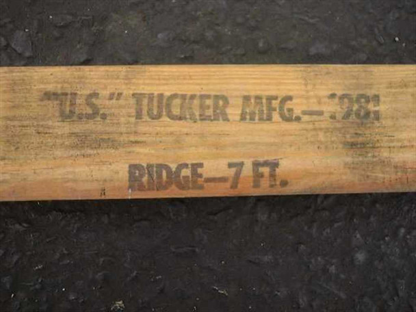 US Tucker Mfg Ridge 7 Ft stamp on wooden tent pole — manufacturer markings close-up