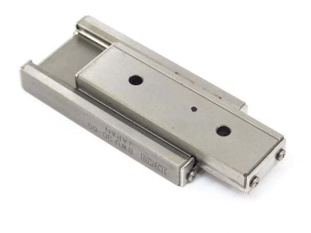 IKO BWU30-60 precision linear slide table — angled top view showing table surface with two mounting holes and IKO BWU30-60 Japan label on rail
