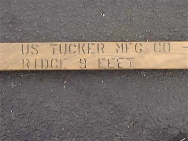Close-up of stenciled markings on US Tucker Mfg Co military ridge tent pole reading 'US TUCKER MFG CO / RIDGE 9 FEET'
