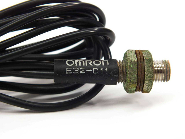 Close-up of Omron E32-D11 label on cable and threaded metal sensing tip showing corrosion on hardware