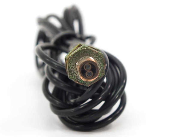 End-on view of Omron E32-D11 fiber sensor tip showing dual optical fiber ends inside threaded hex fitting