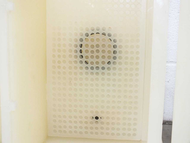 Close-up of PTFE perforated wafer carrier plate inside etch bath showing circular hole pattern