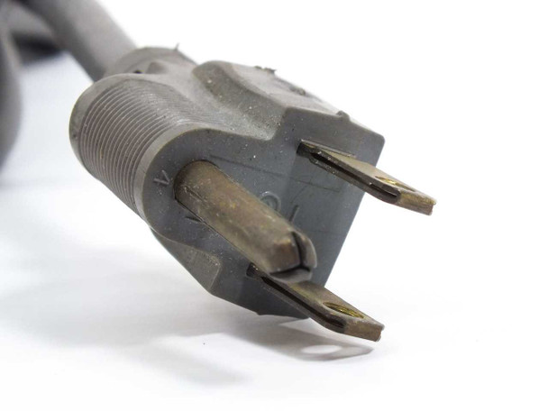 AC power plug closeup showing standard NEMA 5-15 plug with aged prongs