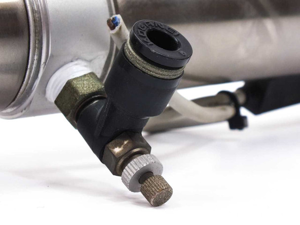 SMC CDM2G32-65-H7BL3 – closeup of elbow-style flow control valve and push-in fitting at cylinder port with needle adjustor