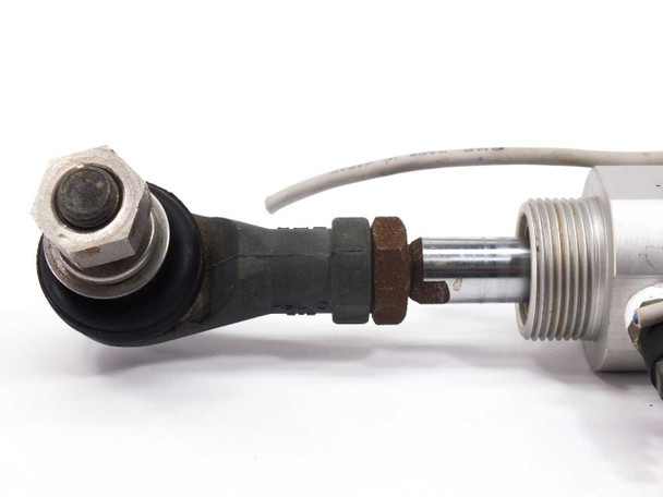 SMC CDM2B32-55 pneumatic cylinder — close-up of left rod end with clevis joint, hex nut, and piston rod detail