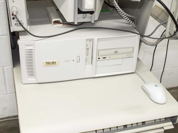 Omnitech CPU system tower with Nicolet Biomedical label, floppy drive, CD drive, and Logitech mouse on cart shelf