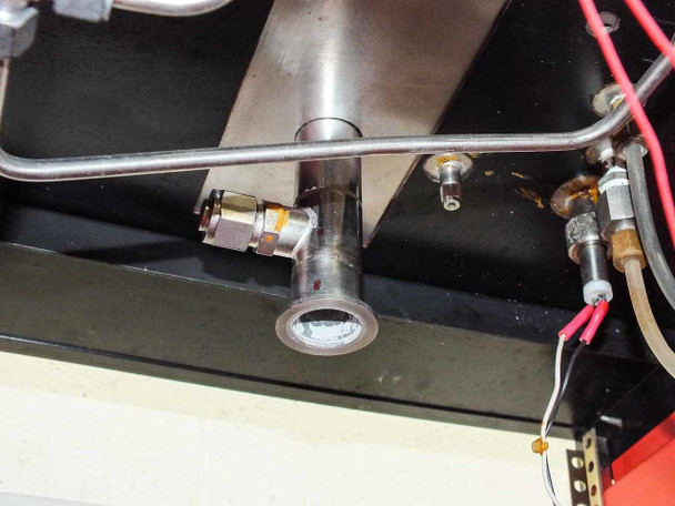 Close-up of vacuum manifold/port area — stainless tube with small viewport or gauge port, brass compression fittings, and signal wiring