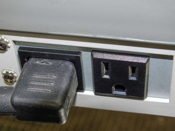 Plus Vision M-10W rear panel showing IEC power inlet with power cord connected and standard AC outlet