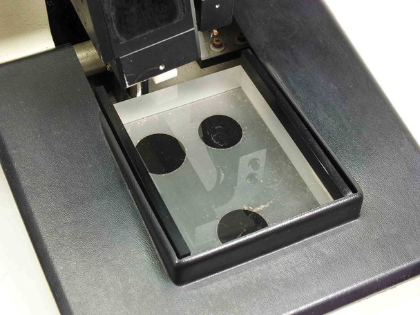 Sloan Dektak IIA scan head stage — top-down view of sample stage showing four circular magnetic sample holders on glass/mirror stage surface