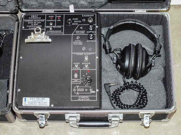 SWAT Console open case showing face plate labeled SWAT CONSOLE with CAMERA SELECTOR, TONE ALERT, INFRARED OVER/UNDER controls, EARMUFF output, E.N.T. CALL BOX label, and over-ear headset