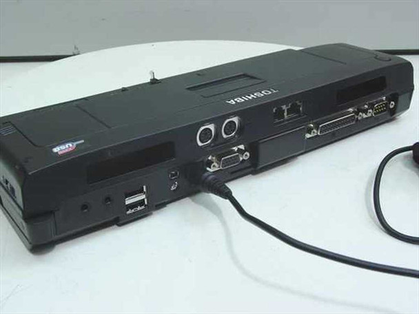 Toshiba Advanced Port Replicator II rear panel showing USB, FireWire, DVI, serial, and parallel ports with AC adapter connected