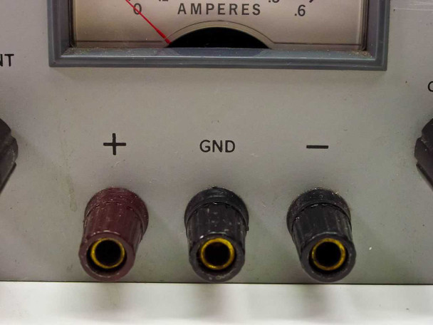 HP Harrison 6102A – close-up of output binding posts labeled +, GND, and – with banana jack connectors