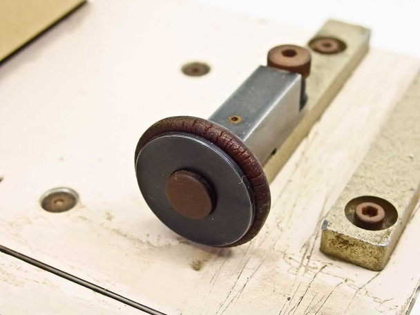 Gryphon 816 Film Splicer – close-up of film transport roller showing cracked rubber wheel and metal axle guide block