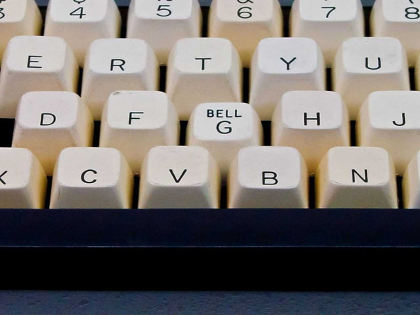 Close-up of center keyboard showing depressed BELL/G key sitting lower than surrounding keys