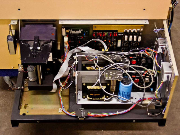 Tegal 701D internal view with cover removed showing motor drive assembly, transformer, large capacitor, control PCBs with relay banks, and wiring harnesses
