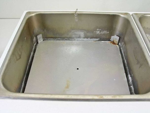 Left bath interior showing stainless steel walls with mineral deposits, rust staining, and heating plate on bottom