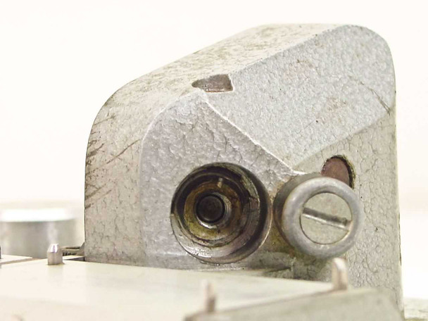 Hollywood Film Company TS-16 — side close-up of pivot block showing pivot bore, retaining screw, and worn cast aluminum surface; gripper swing arm mount visible but arm absent