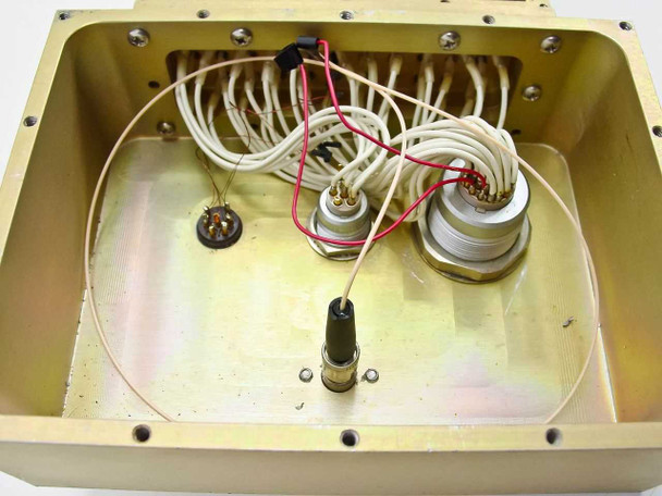 Interior of brass enclosure box – close-up view of internal wiring including red and white wire leads, ceramic pin connectors, and coaxial connector stub