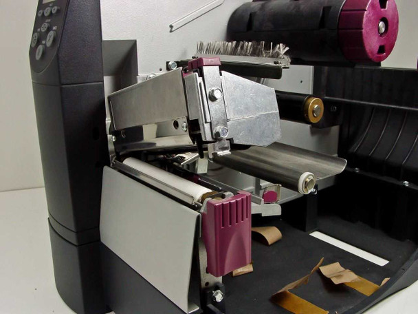 Zebra Z4 label printer interior with lid open showing printhead assembly, platen, and ribbon mechanism from above