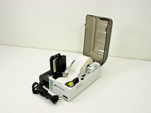 Zebra Bravo Desktop Printer with lid open showing internal paper path, media roll, and external power adapter