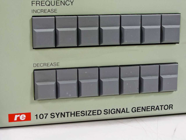 RE 107 Synthesized Signal Generator front panel detail — close-up of FREQUENCY INCREASE and DECREASE pushbutton rows and RE 107 SYNTHESIZED SIGNAL GENERATOR nameplate badge