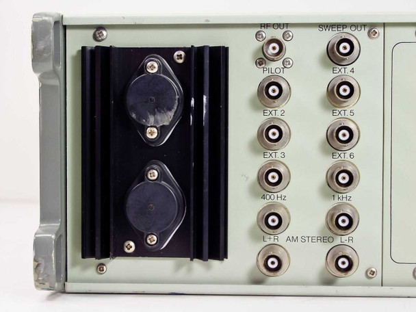 RE 107 Synthesized Signal Generator rear panel left section — dual heatsink-mounted power transistors and BNC output array labeled RF OUT, PILOT, EXT 2–6, SWEEP OUT, 400 Hz, 1 kHz, L+R, AM STEREO, L-R