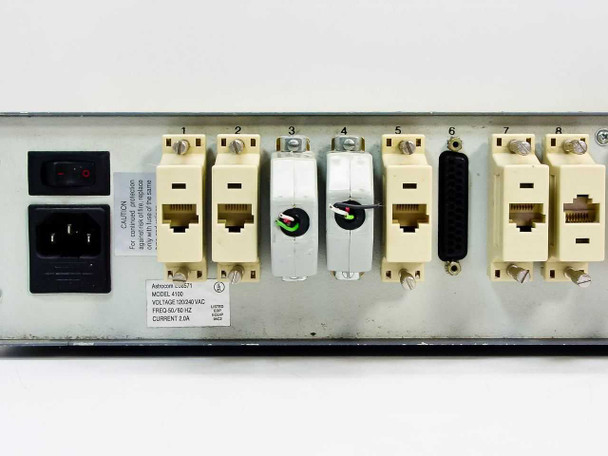 Astrocom 4100 rear panel left-side detail showing IEC AC inlet, power switch, ports 1–8 with mixed RJ-45 and DB connectors, and rating label