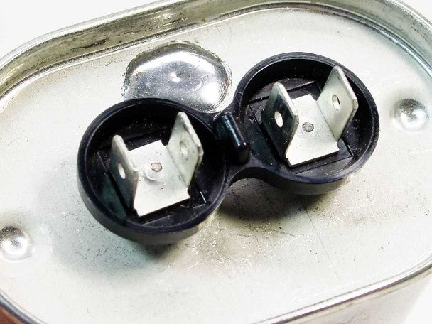 CDE KTSM37U506M3E run capacitor – top view showing dual quick-connect blade terminal clusters in black housing