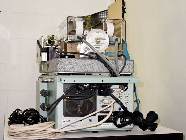 Guzik S1701 SpinStand rear and underside view showing granite base, cooling fan, interconnect wiring, and Guzik Technical Enterprises chassis label