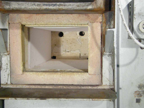 Hevi-Duty HDT-5610 furnace chamber interior — refractory firebrick walls with two thermocouple ports visible, chamber floor showing use wear and minor cracking