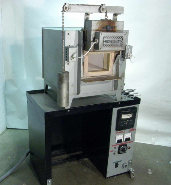 Hevi-Duty HDT-5610 electric box furnace front view — door open showing refractory chamber, mounted on black cabinet base with Barber-Colman controller panel below